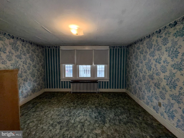 unfurnished room with carpet and radiator heating unit