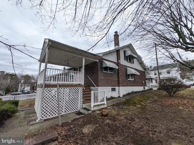 view of side of property with covered porch