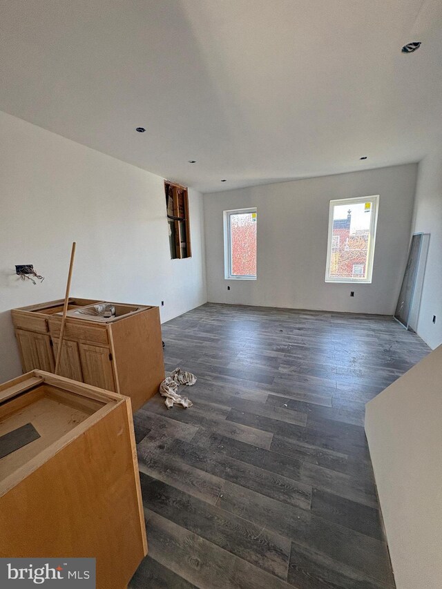 unfurnished living room with dark wood-type flooring