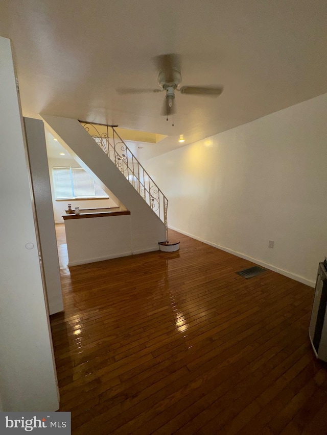 unfurnished living room with ceiling fan and dark hardwood / wood-style floors