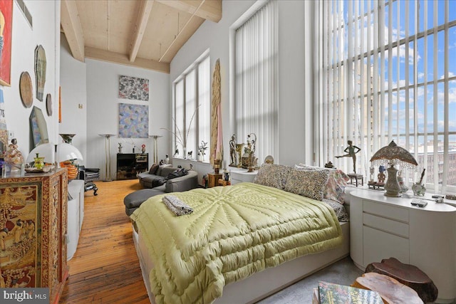 bedroom with hardwood / wood-style floors, beam ceiling, and wood ceiling