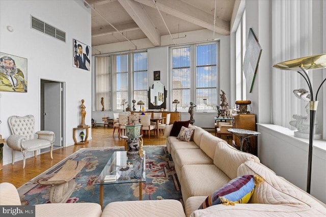 living room featuring beamed ceiling and wood-type flooring