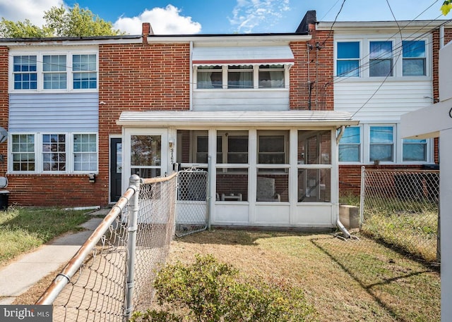 townhome / multi-family property featuring a front yard and a sunroom