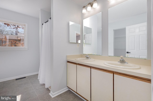 full bathroom featuring tile patterned flooring, visible vents, double vanity, and a sink