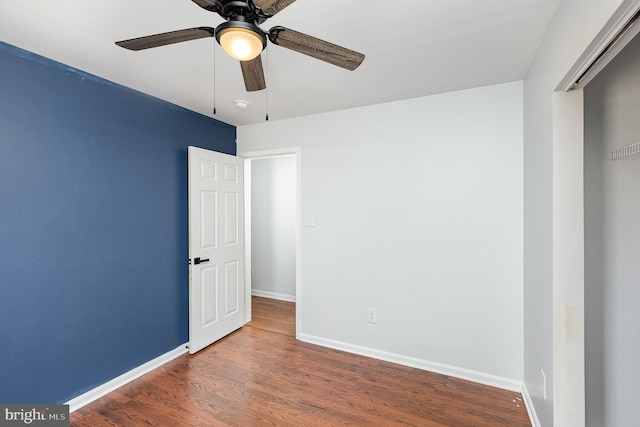 unfurnished room with a ceiling fan, wood finished floors, and baseboards