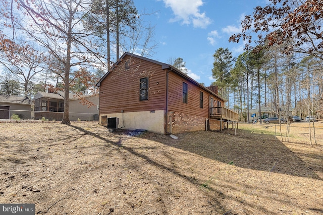 view of home's exterior featuring central air condition unit, a chimney, and fence