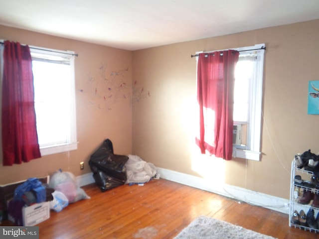 interior space with cooling unit and hardwood / wood-style flooring