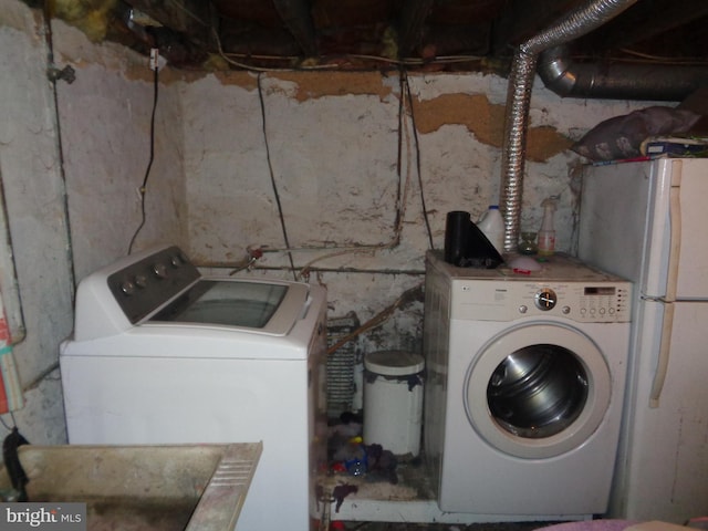 clothes washing area featuring independent washer and dryer and sink