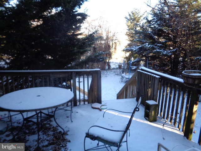 snow covered patio featuring a wooden deck