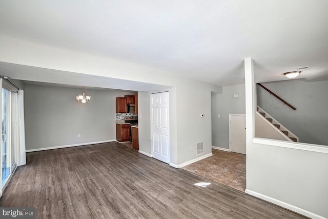 unfurnished living room with a chandelier and hardwood / wood-style flooring