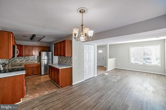 kitchen with a chandelier, decorative light fixtures, stainless steel appliances, and decorative backsplash