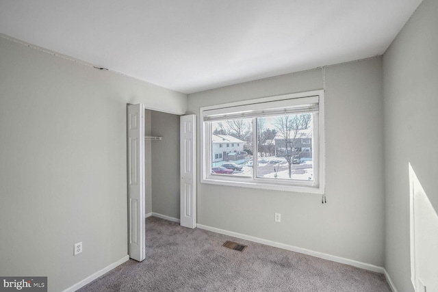 unfurnished bedroom featuring light colored carpet and a closet