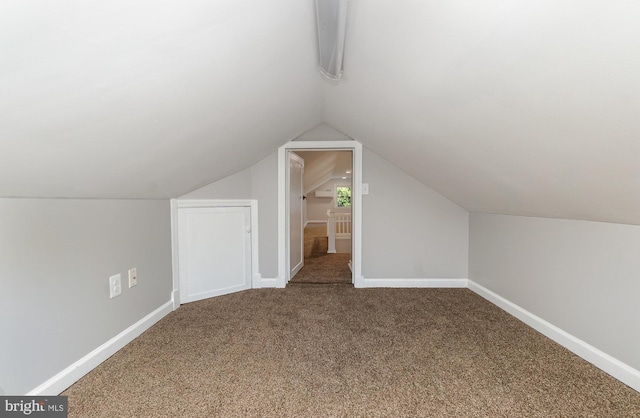 additional living space featuring carpet flooring and vaulted ceiling