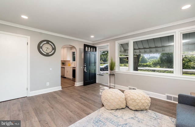 unfurnished room featuring ornamental molding and hardwood / wood-style flooring