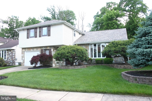 view of front of property featuring a front lawn and a garage