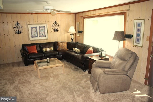 living room with carpet flooring, ceiling fan, and wood walls