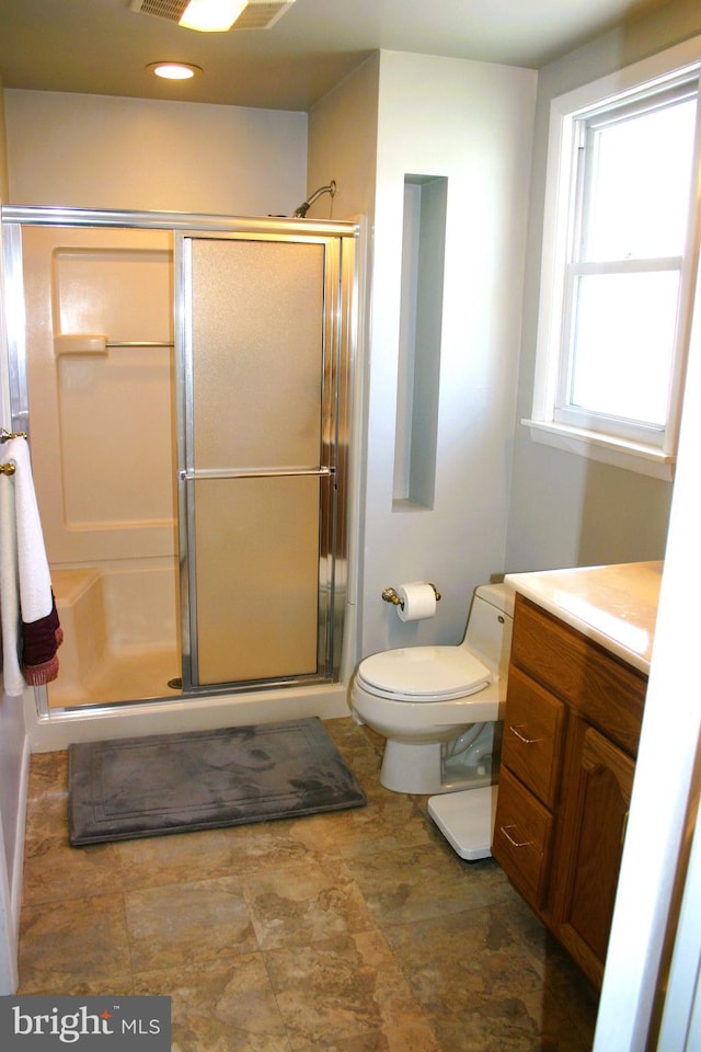 bathroom with vanity, toilet, and an enclosed shower