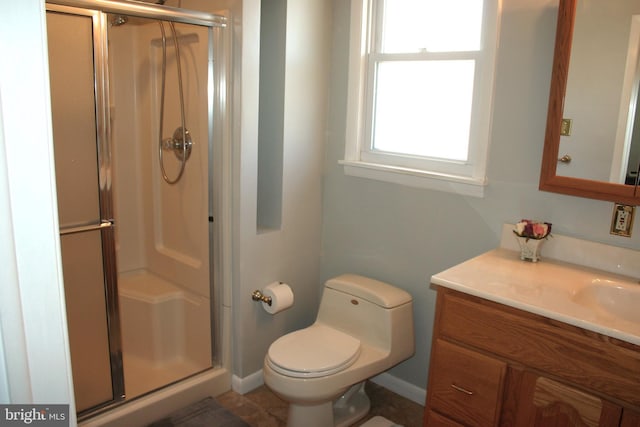 bathroom with vanity, a shower with shower door, and toilet