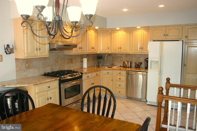 kitchen with sink, decorative backsplash, appliances with stainless steel finishes, light tile patterned flooring, and light stone counters