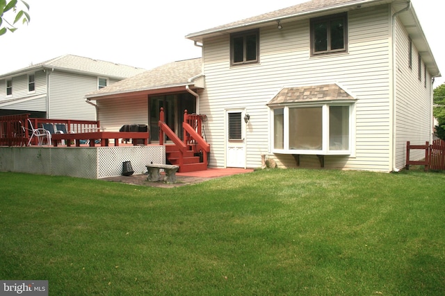 rear view of house featuring a deck and a yard