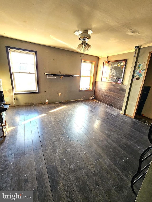 empty room with ceiling fan and dark wood-type flooring