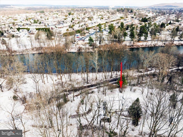 snowy aerial view featuring a water view