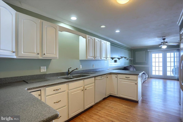 kitchen with white cabinets, white dishwasher, kitchen peninsula, and sink