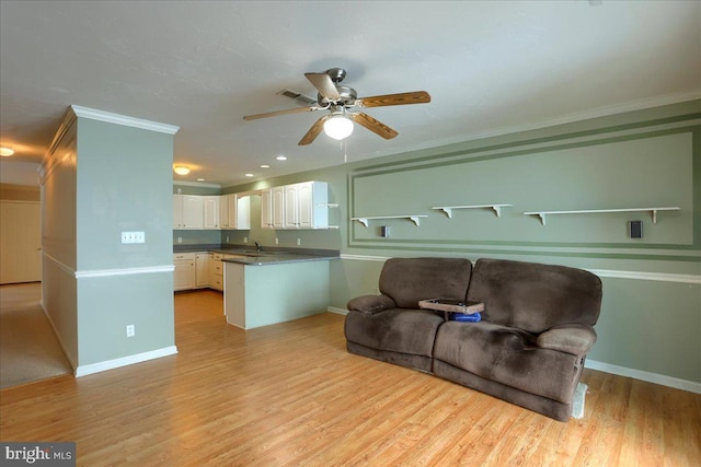 living room with crown molding, sink, ceiling fan, and light hardwood / wood-style floors