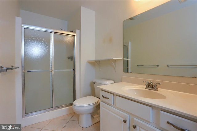 bathroom with tile patterned floors, a shower with door, vanity, and toilet