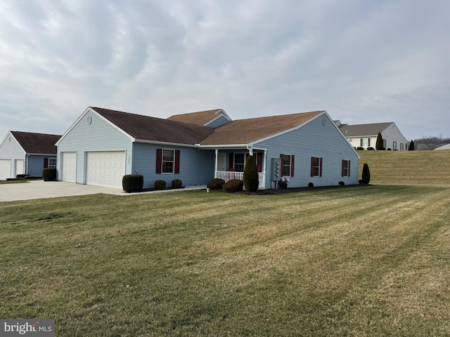 ranch-style home featuring covered porch, a garage, and a front yard