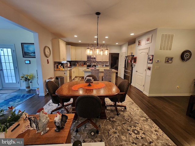 dining room featuring dark hardwood / wood-style flooring and an inviting chandelier