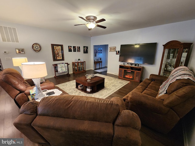 living room featuring ceiling fan and dark hardwood / wood-style floors