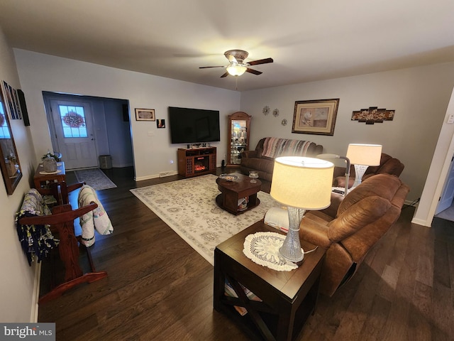 living room with ceiling fan and dark wood-type flooring