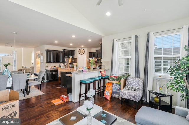 living room featuring ceiling fan, dark wood-type flooring, and vaulted ceiling