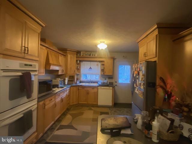 kitchen with sink, white appliances, and light brown cabinets