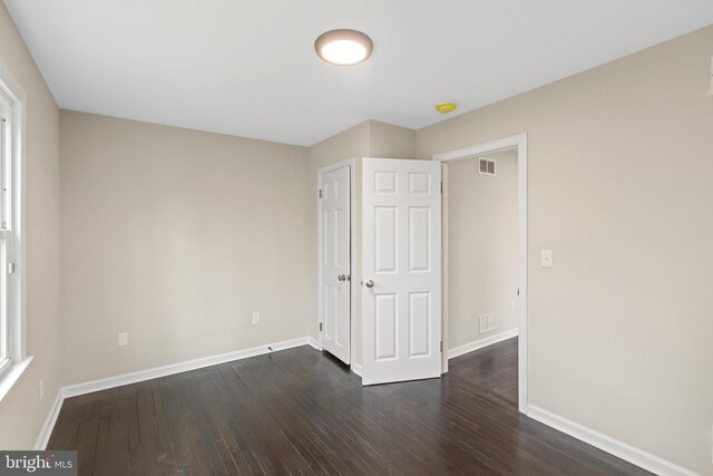 unfurnished bedroom featuring dark hardwood / wood-style floors