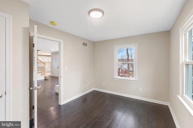 empty room with dark hardwood / wood-style flooring