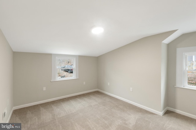 empty room with light carpet and vaulted ceiling