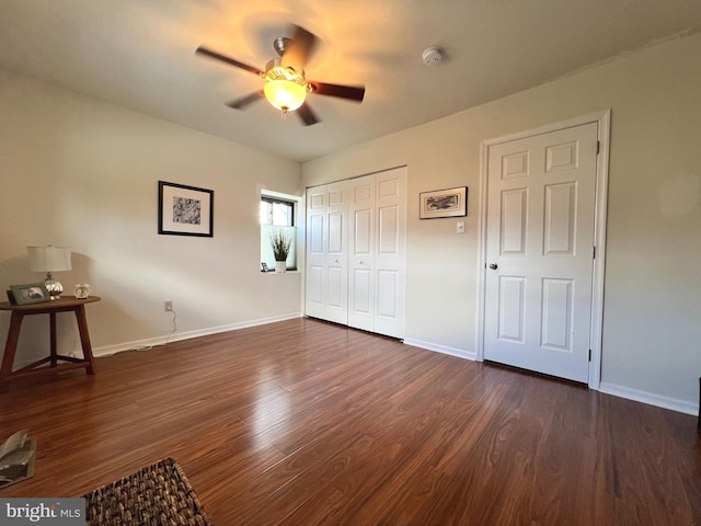 unfurnished bedroom featuring a closet, ceiling fan, and dark hardwood / wood-style flooring