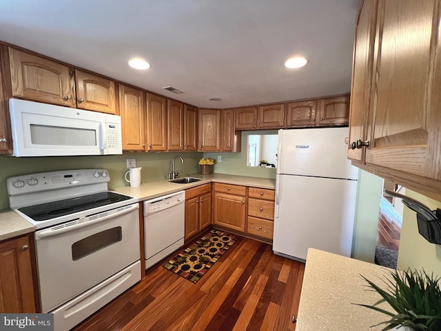 kitchen featuring white appliances, sink, and dark wood-type flooring