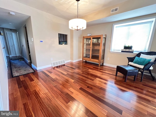 unfurnished room with wood-type flooring and a notable chandelier