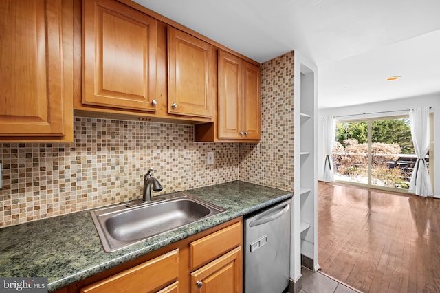 kitchen with dishwasher, sink, tile patterned floors, dark stone counters, and decorative backsplash