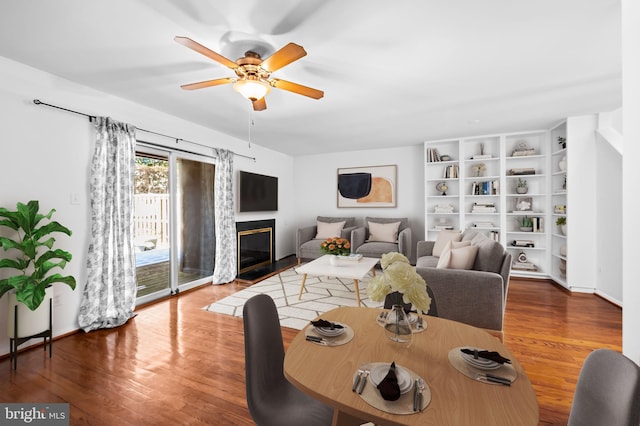 dining space with hardwood / wood-style flooring, ceiling fan, and built in shelves