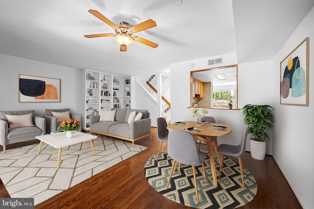 living room featuring ceiling fan and dark wood-type flooring