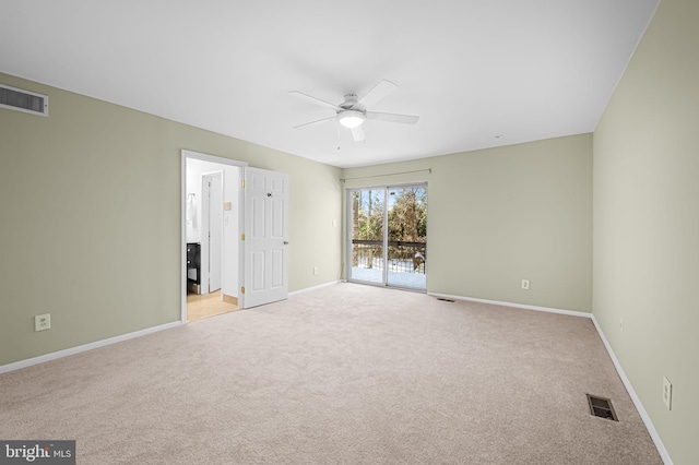 carpeted spare room featuring ceiling fan