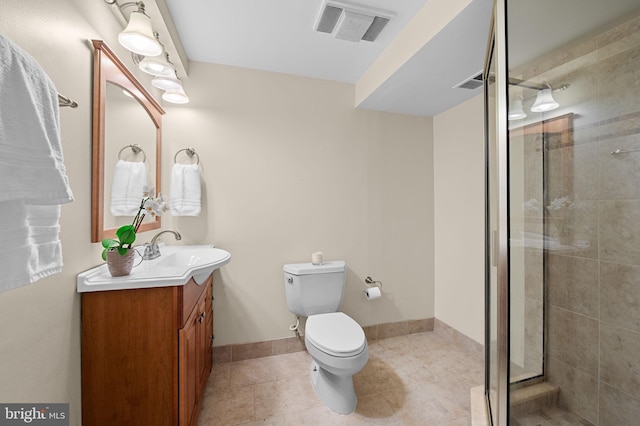 bathroom featuring tile patterned floors, vanity, toilet, and walk in shower