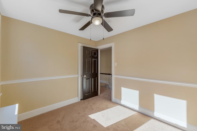 empty room featuring light colored carpet and ceiling fan