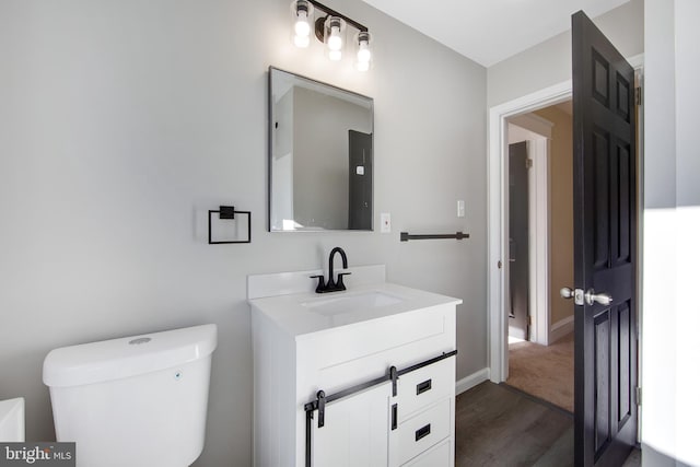 bathroom with vanity, hardwood / wood-style flooring, and toilet