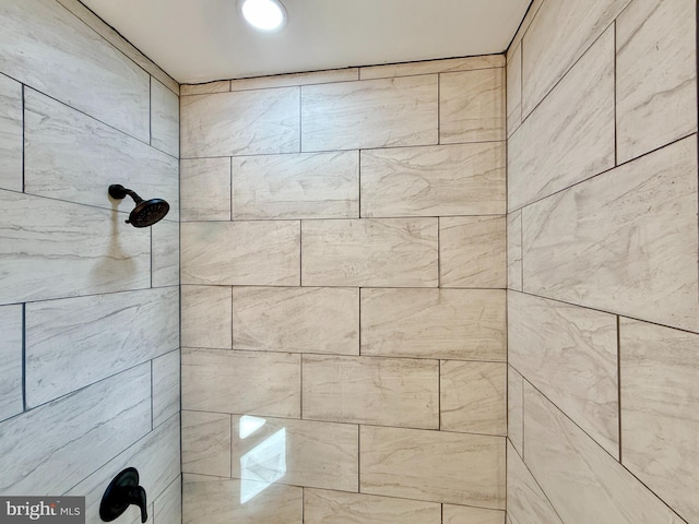 interior details featuring a tile shower