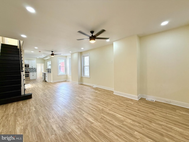 unfurnished living room with ceiling fan and light hardwood / wood-style floors